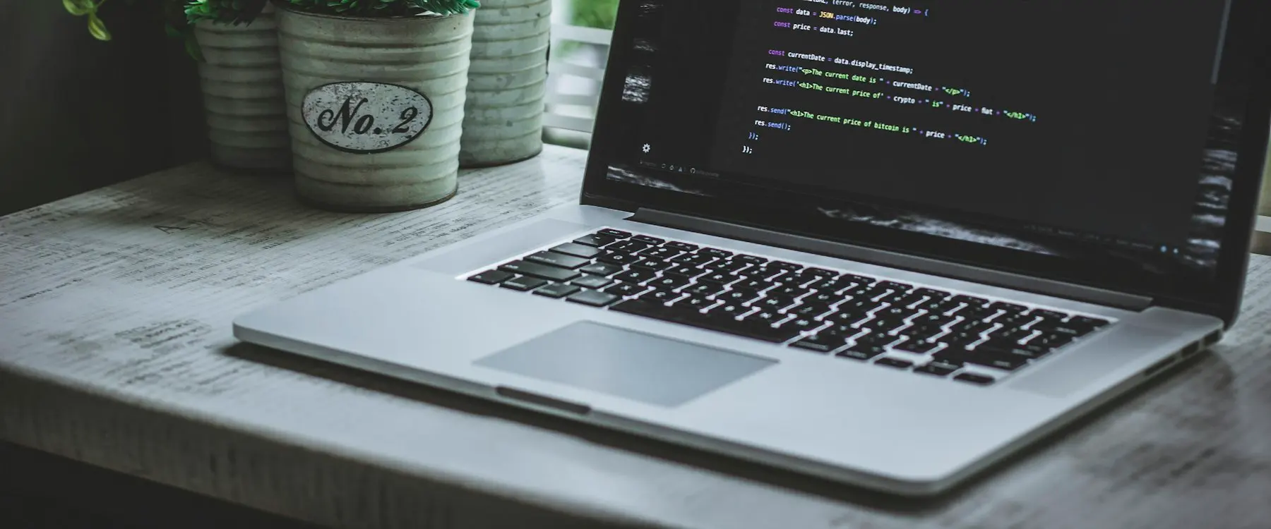 A laptop showing code on a bright desk