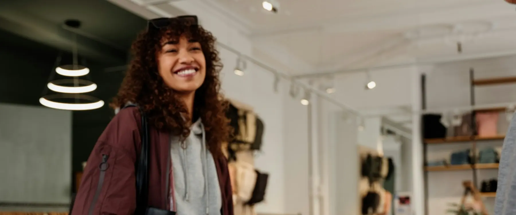 Une commerçante souriante utilise une caisse numérique