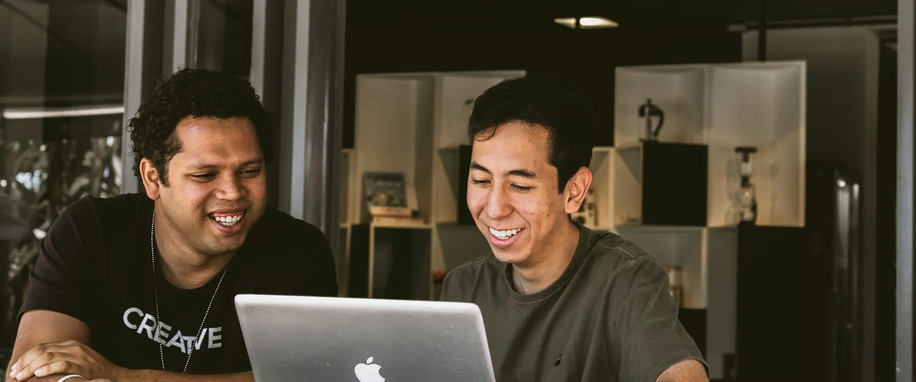 Deux fondateurs souriants devant un ordinateur portable