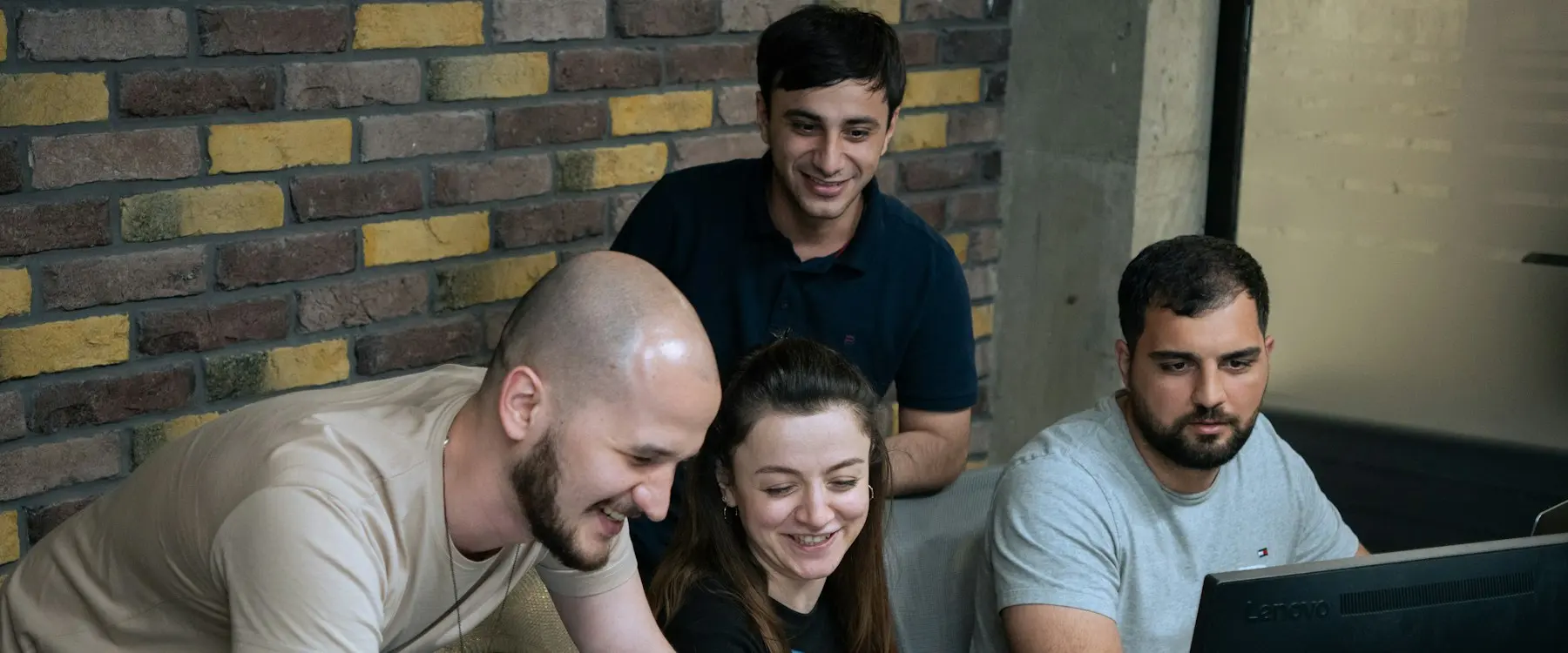 Smiling colleagues in front of a laptop