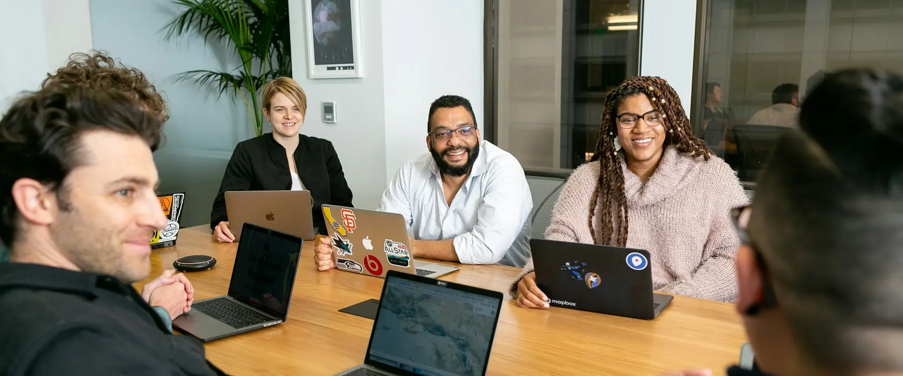 Réunion d’équipe autour d’une table avec des ordinateurs portables