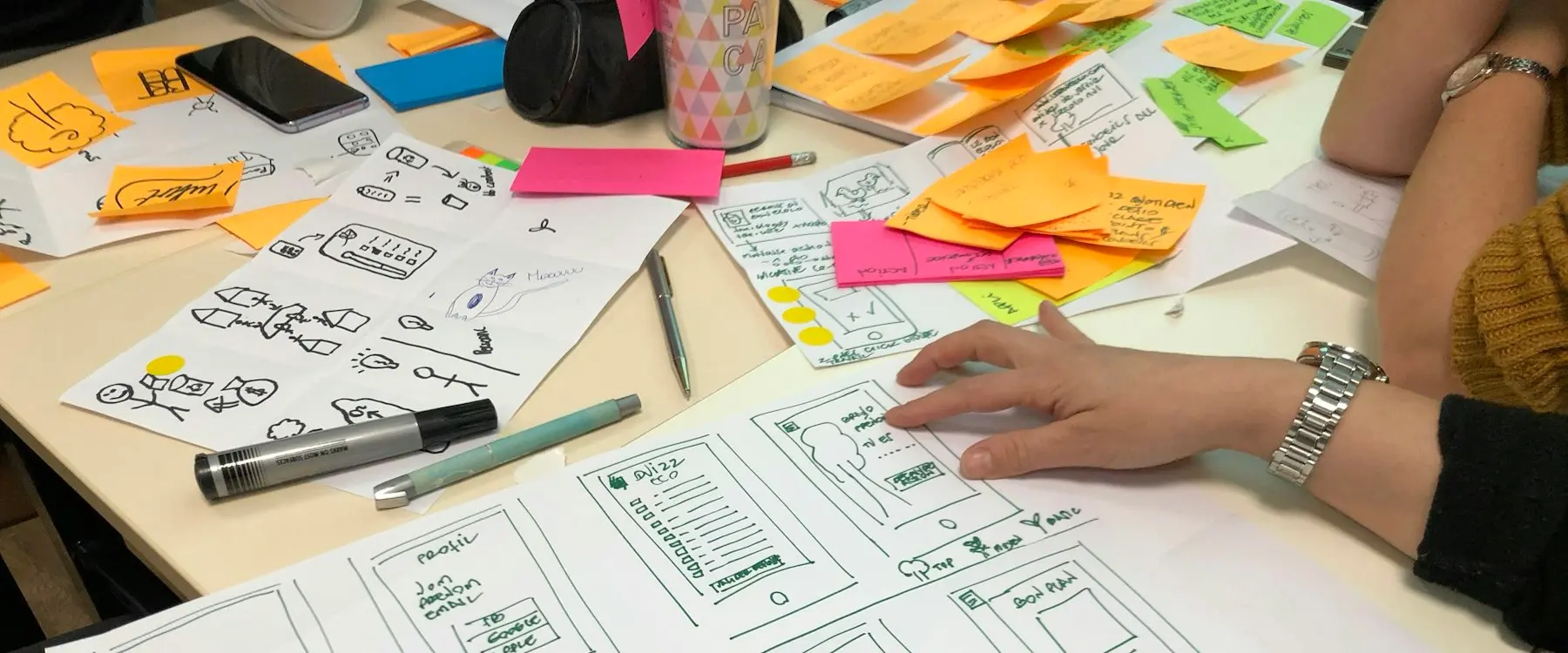 Maquettes papier et notes adhésives sur une table de travail